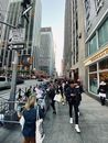 人们走在高楼林立的繁华城市街道上，捕捉着城市生活