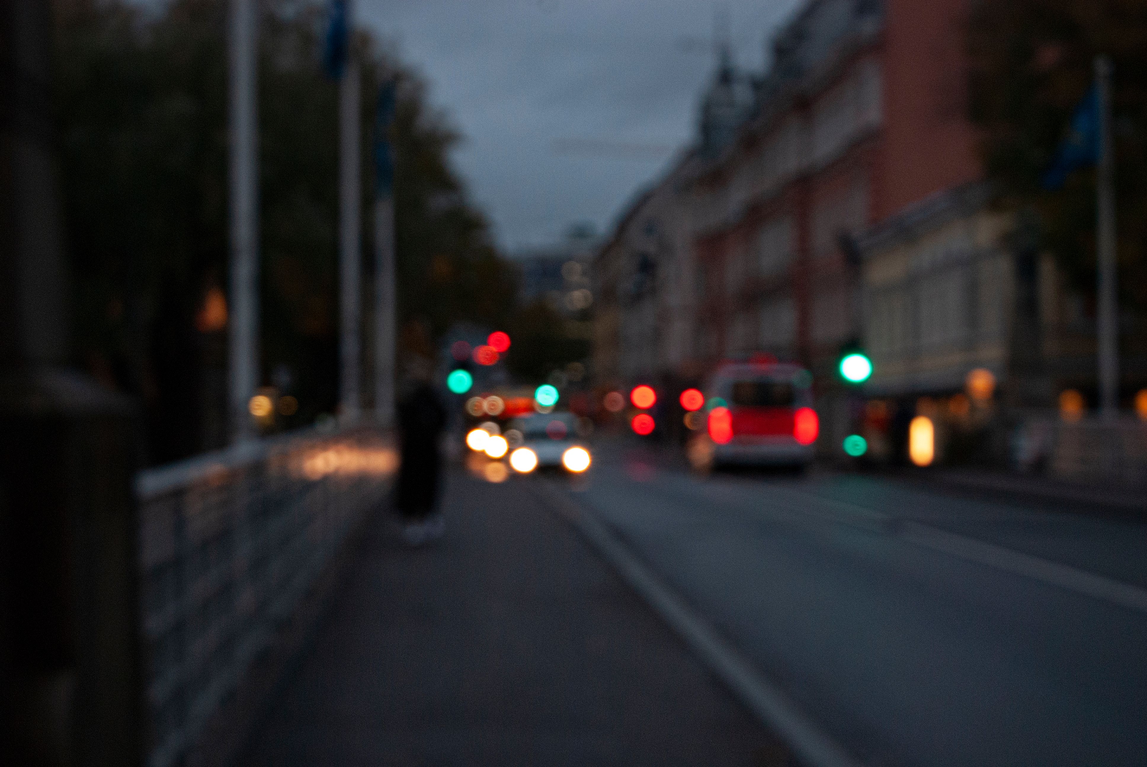 夜晚的城市街道景色模糊，车辆和红绿灯都亮着