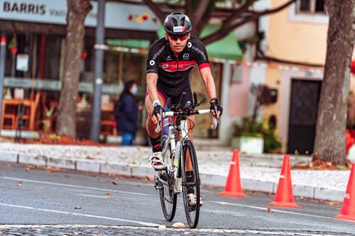Free Cyclist in sportswear racing through city streets during the day. Stock Photo