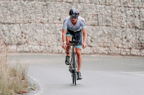 Man in Black Helmet Riding Bicycle on Road