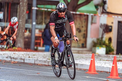 Man in Black Helmet Riding on Black Bicycle on Road