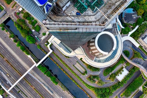 Free Aerial view of asphalt road and narrow canal in modern city near skyscraper with glass walls on sunny day Stock Photo