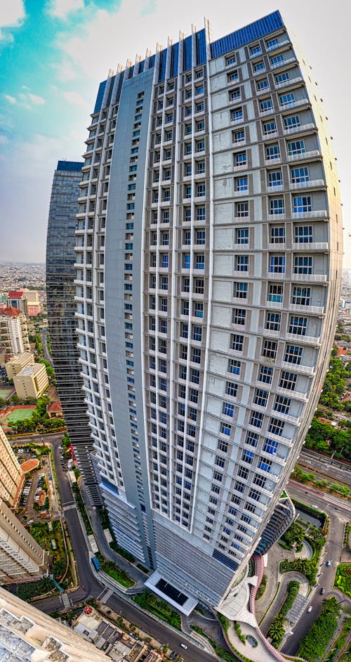 Exterior of modern multistage building with geometric design located at roadside in residential district of megapolis on sunny day