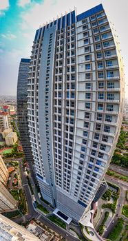 Exterior of modern multistage building with geometric design located at roadside in residential district of megapolis on sunny day - Fotografer Sidoarjo