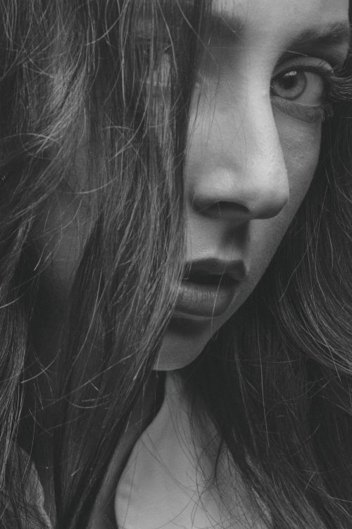 Free Captivating grayscale close-up of a woman's face, highlighting intense expression and texture. Stock Photo