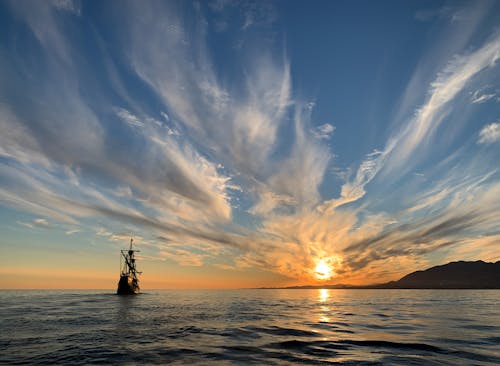 Silhouette of Ship on Sea during Sunset