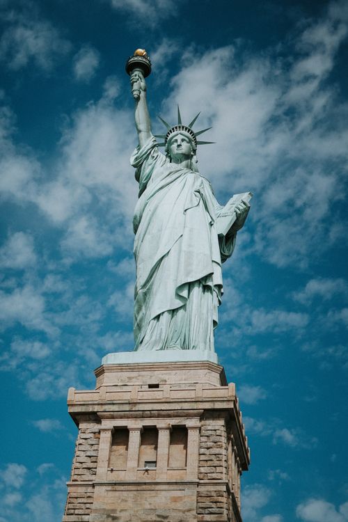 Free The Statue of Liberty standing tall against a clear blue sky in New York City. Stock Photo