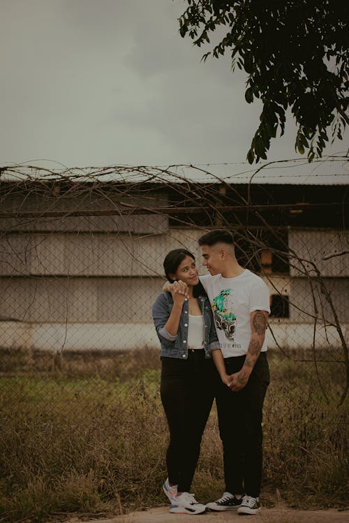 A Couple Standing Near a Fence