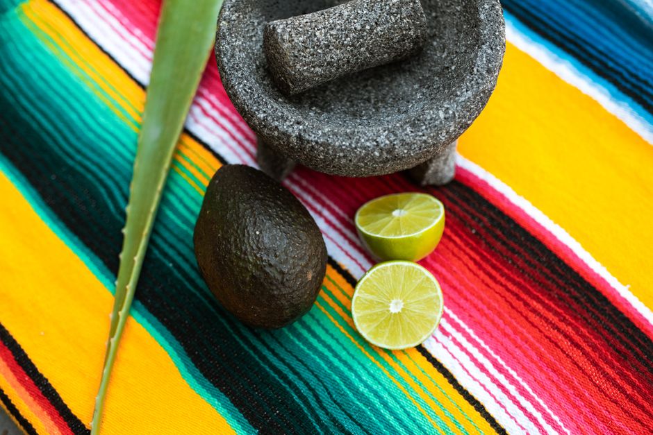A halved avocado with the pit removed, brushed with lime juice and pressed tightly under plastic wrap to limit air exposure.