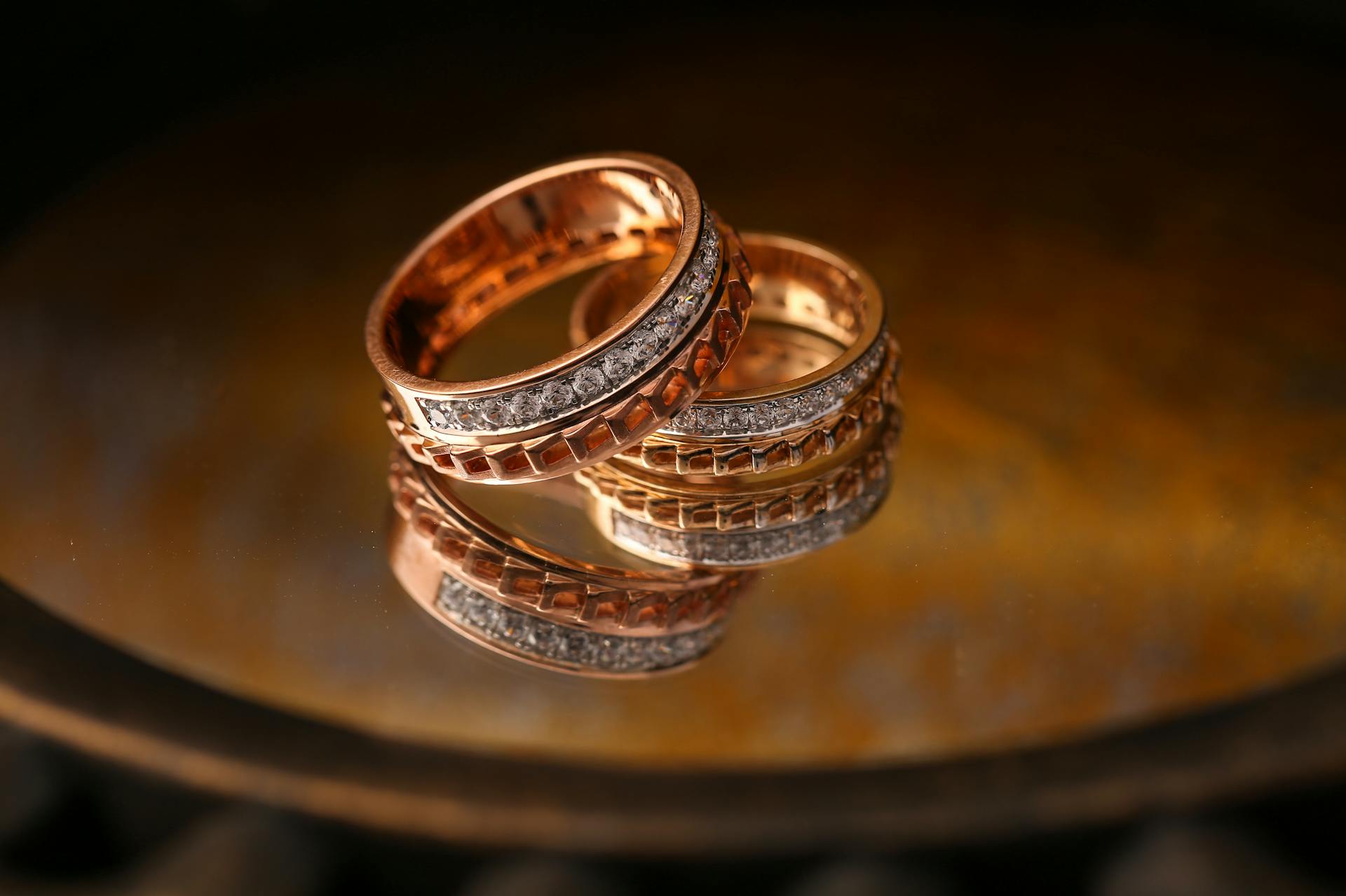 Close-up of luxury gold and diamond wedding rings reflecting light beautifully.