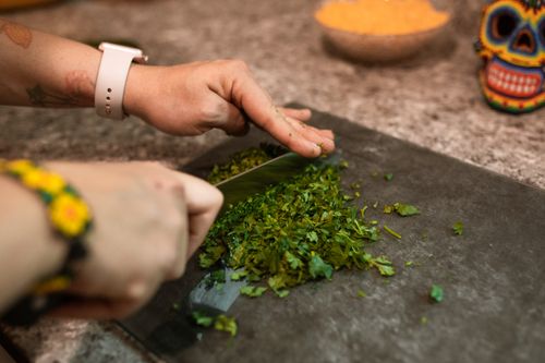 Free Hands chopping fresh herbs on a cutting board, capturing food preparation process. Stock Photo