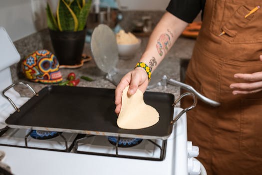 Chef prepares homemade tortillas on the stove with tattoos visible.