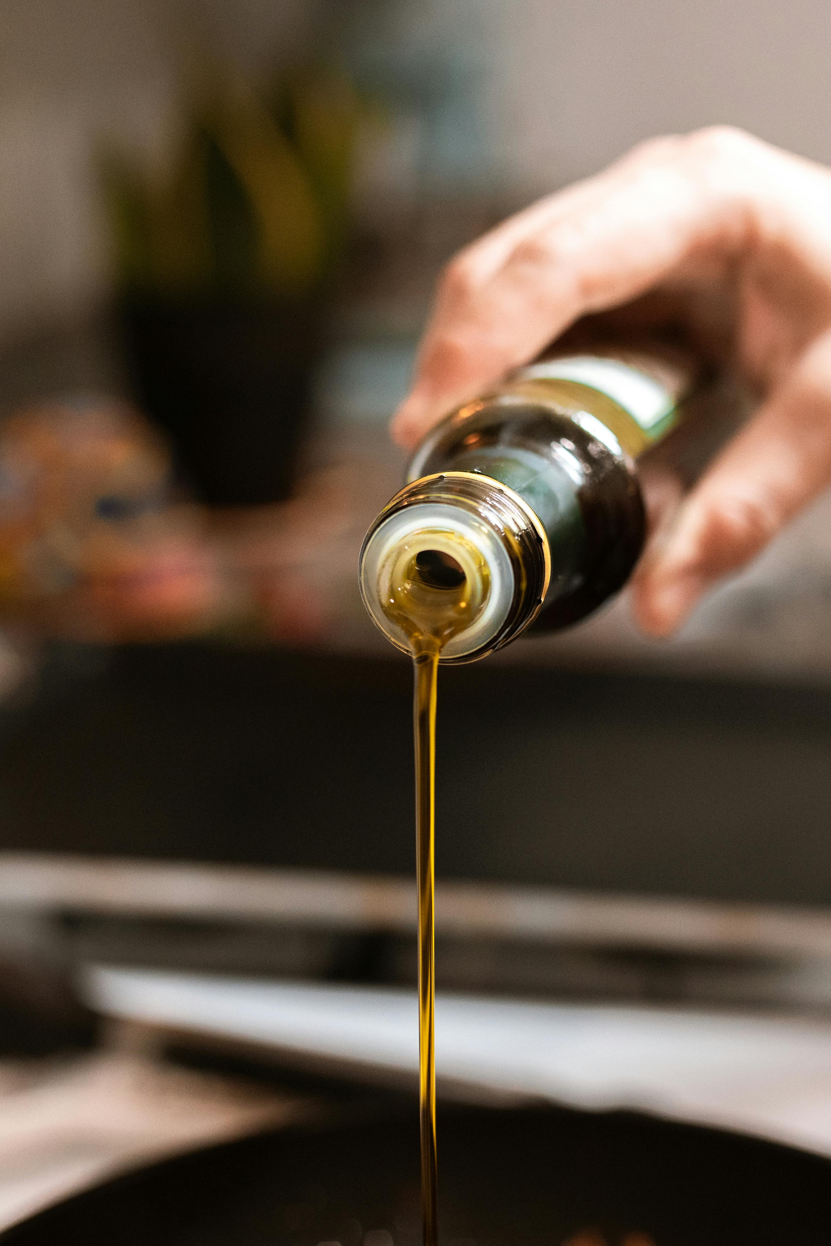 person pouring olive oil