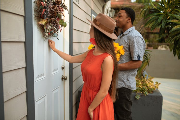 A Woman In Orange Dress Knocking On The Door