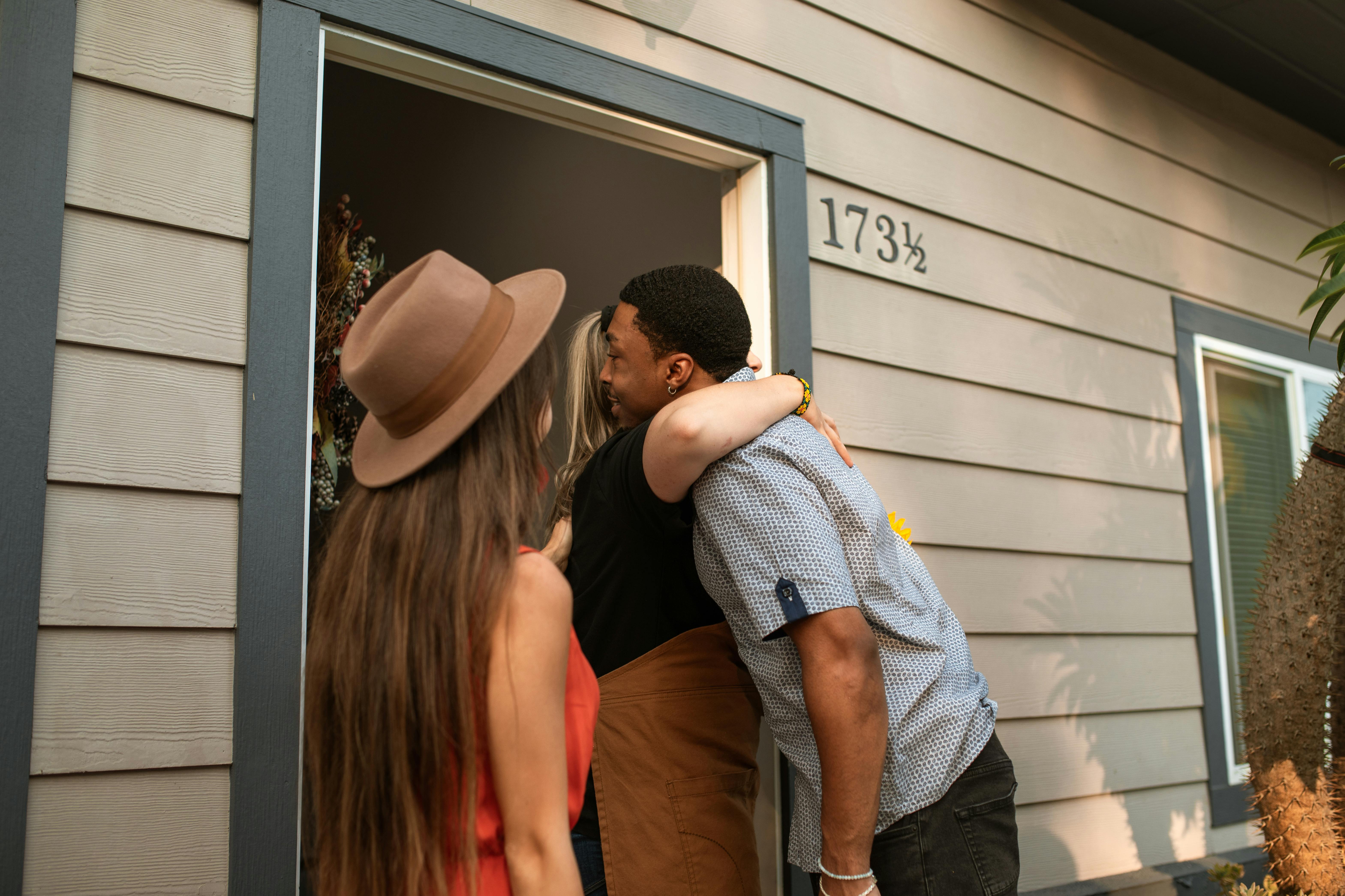 a person hugging a man at the doorway