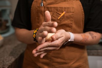 Baker shaping a small round of dough by hand, photo by RDNE Stock project on Pexels