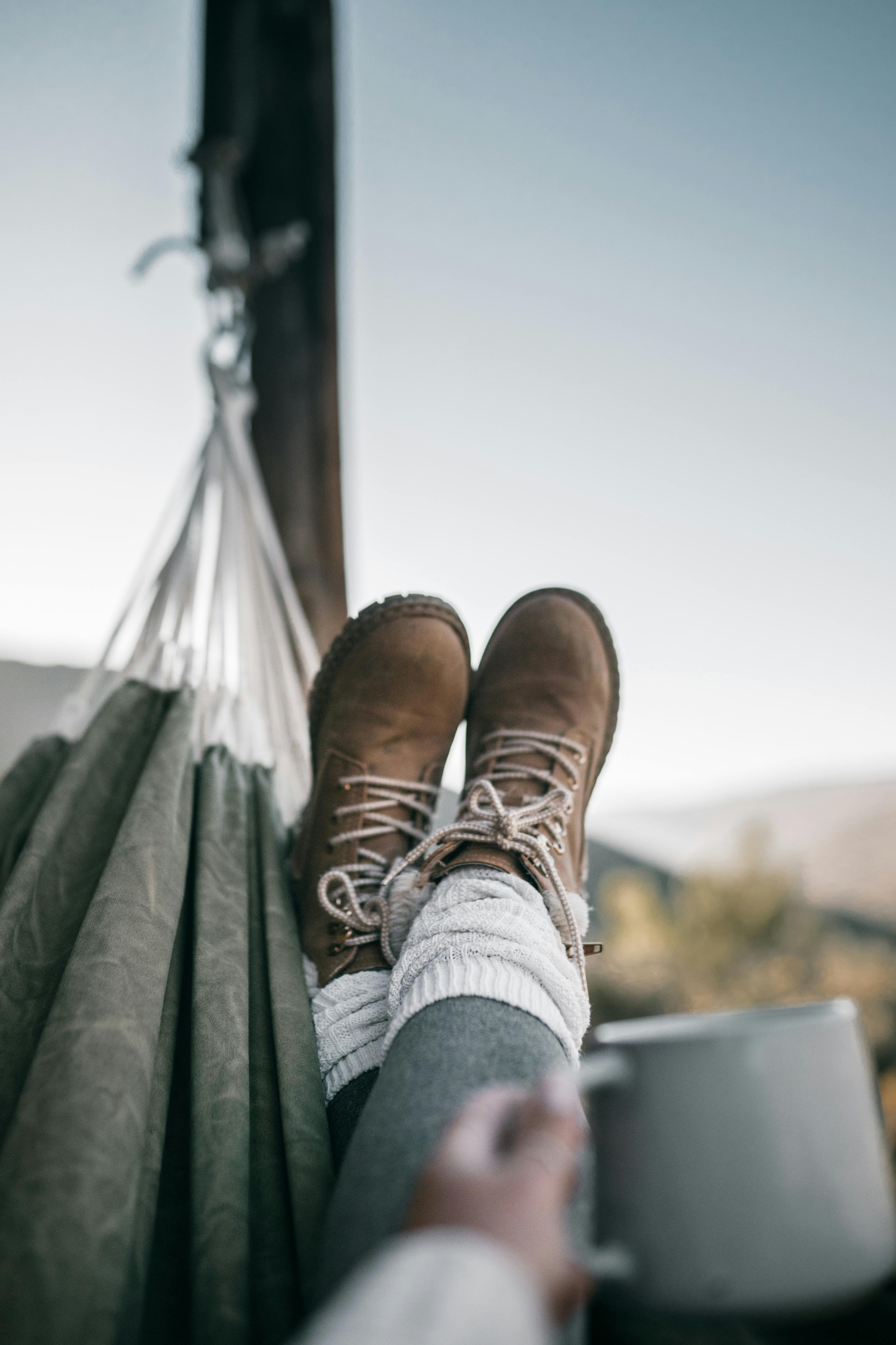 person in hiking boots on hammock