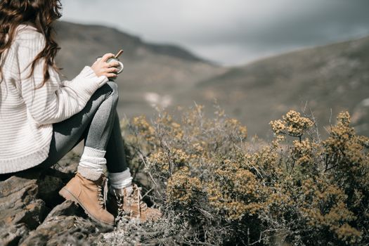 年轻女子在美丽的山间享受一杯平静的咖啡，这非常适合冒险和旅行主题