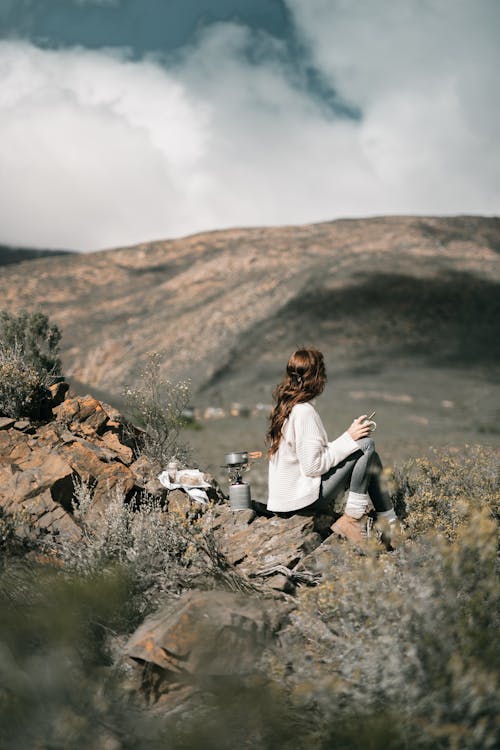 Free  Woman Holding a Cup Overlooking Rocky Valley Stock Photo