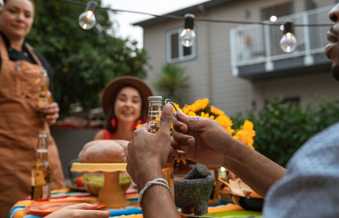 Friends gather outdoors sharing beers and enjoying festive vibes.