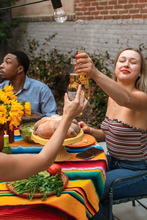 Free Group of friends celebrating with drinks and food outdoors. Festive and joyful setting. Stock Photo