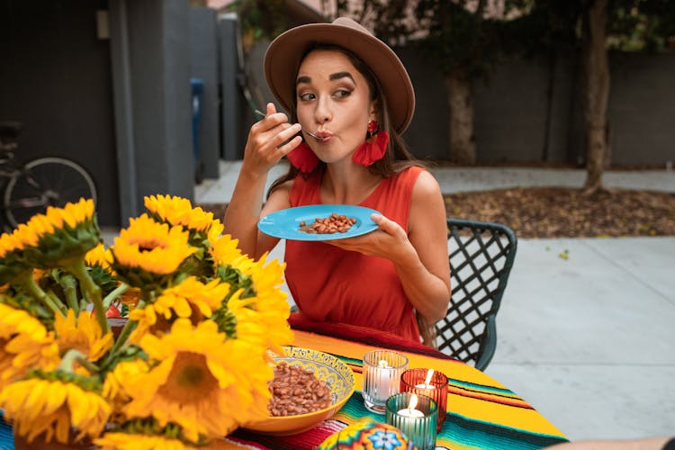 Woman Wearing Red Dress Eating Beans