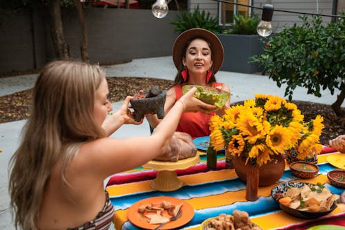 Free Women Passing Foods on the Table Stock Photo