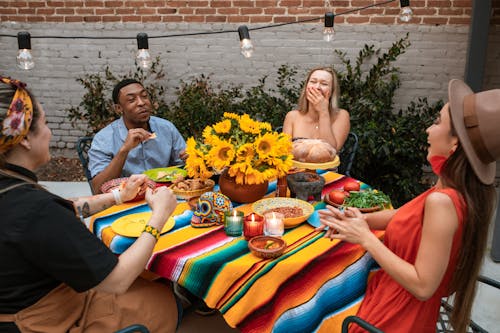 A Group of Friends Laughing while Sitting Near the Table