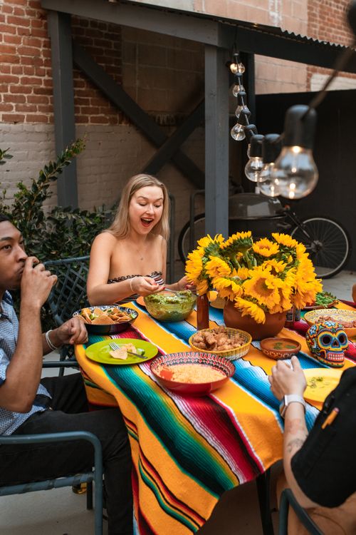 Free Group of friends enjoying a colorful outdoor meal in a garden setting. Stock Photo