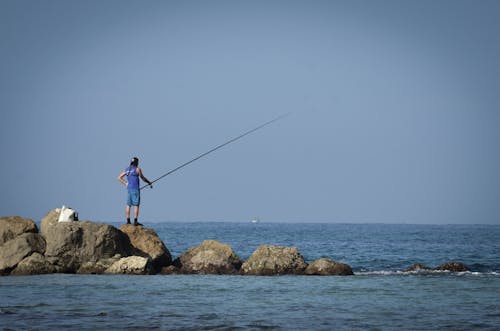 Free Photograph of a Man in a Blue Top Fishing Stock Photo