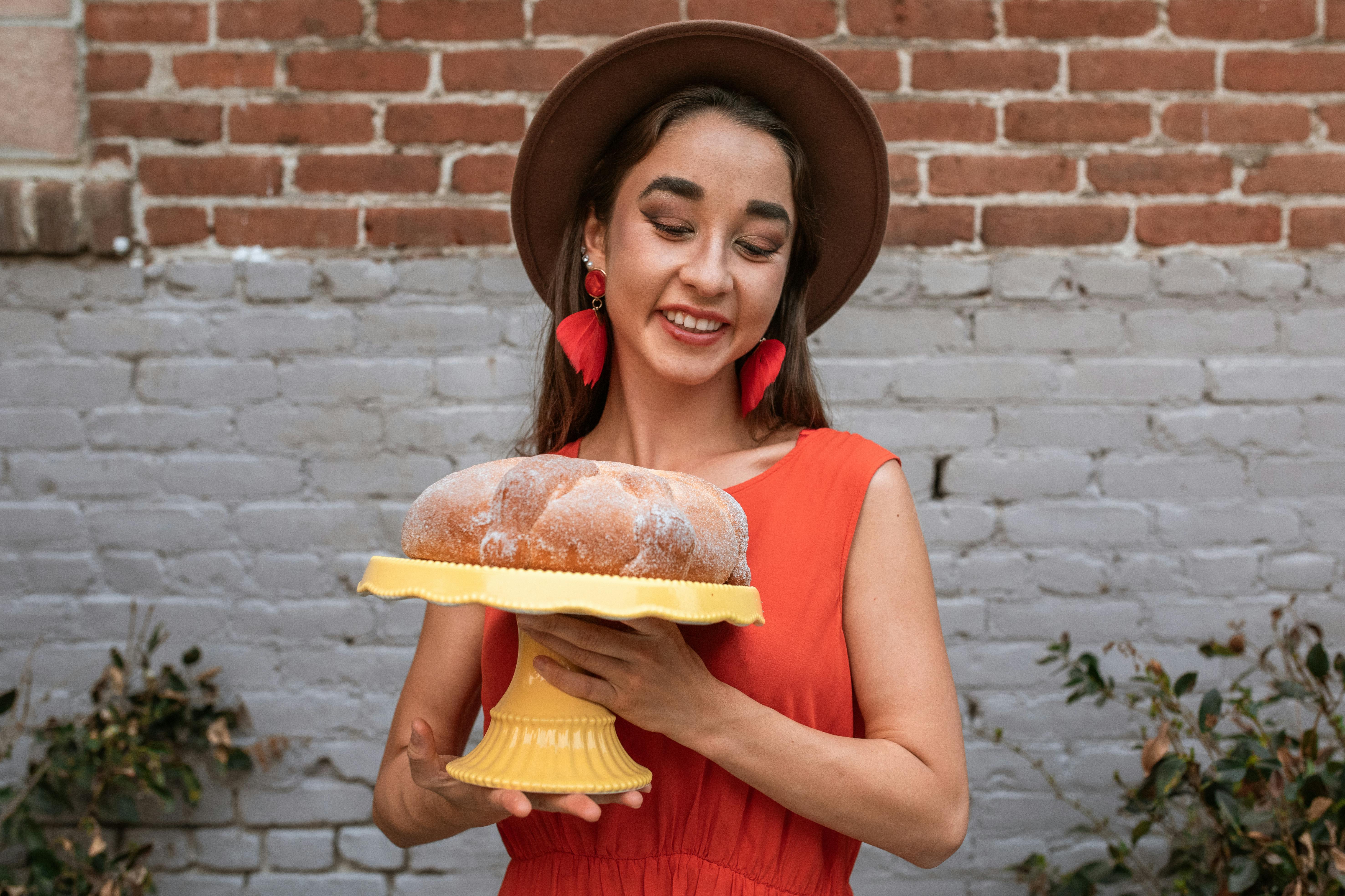 Smiling Woman Holding a Cake Stand · Free Stock Photo