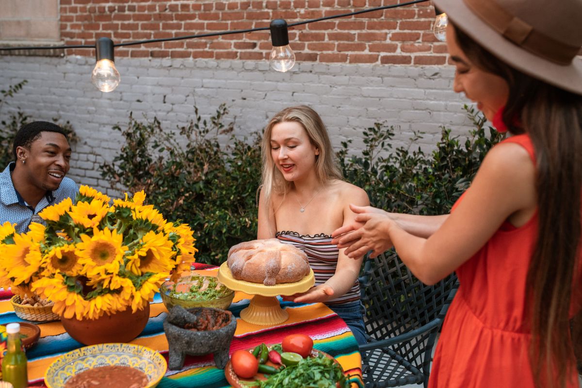 People sharing food together in an outdoor garden, illustrating intentional community and ecovillage life