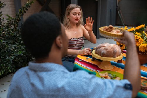 Free Two young friends enjoying a relaxed meal outdoors, sharing food and conversation. Stock Photo