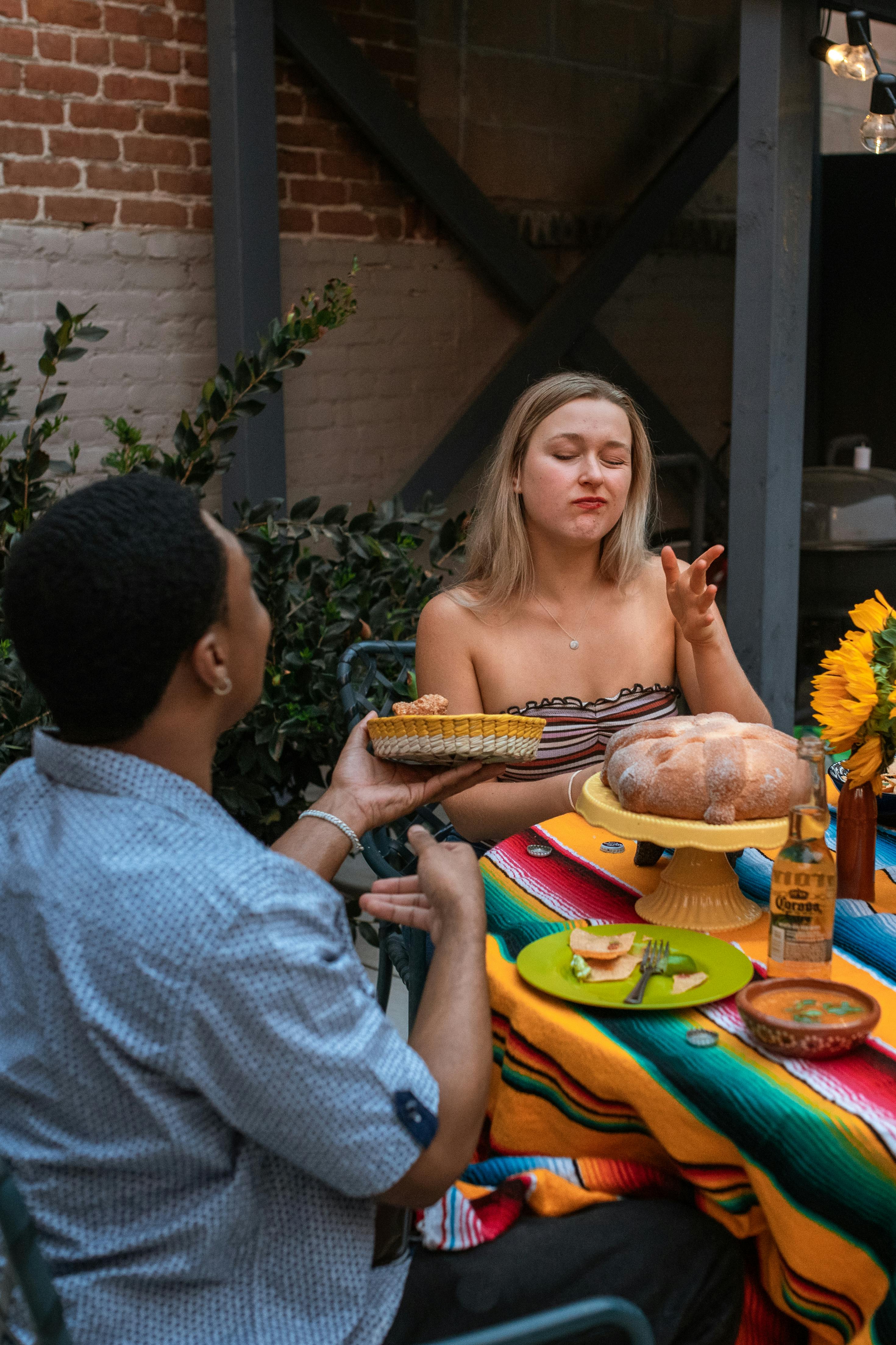 Vibrant outdoor dining scene with friends enjoying food and drinks in a garden setting.