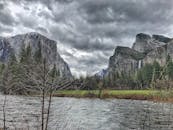 优胜美地山谷景色迷人，有暴风雨的云层、郁郁葱葱的森林和流淌的河流
