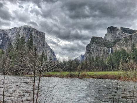 优胜美地山谷景色迷人，有暴风雨的云层、郁郁葱葱的森林和流淌的河流