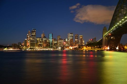 A captivating nighttime cityscape of Sydney with illuminated skyline and iconic Harbor Bridge.