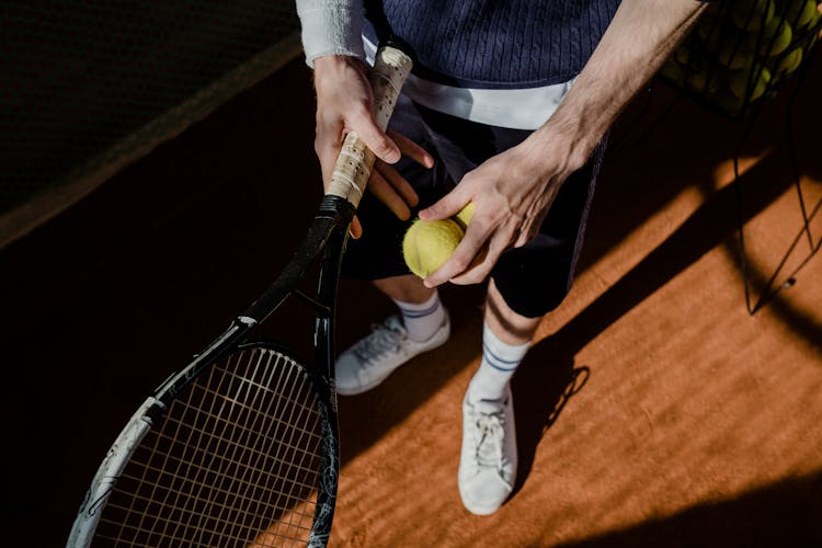 A Person Holding A Tennis Racket