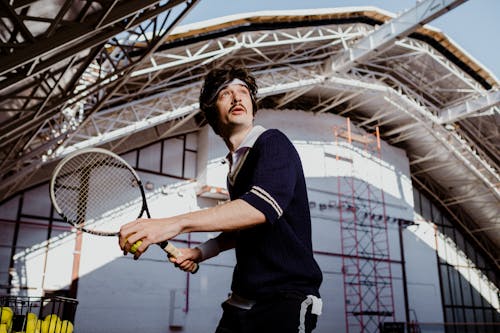 Man in Black Polo Shirt Holding Tennis Racket