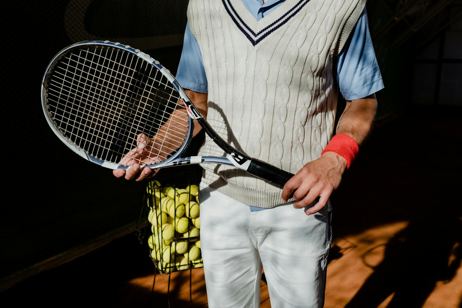 Person in Blue and White Shirt and White Pants Holding Black and White Tennis Racket