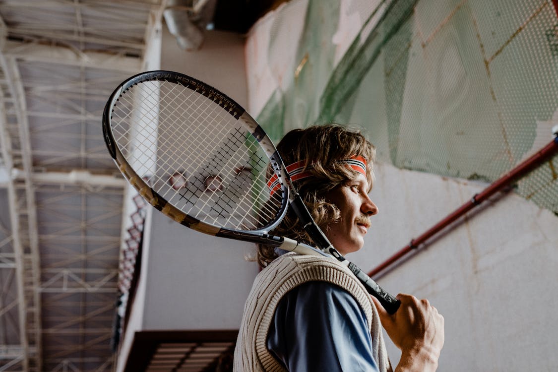 Woman in White and Black Stripe Shirt Holding Black and White Tennis Racket