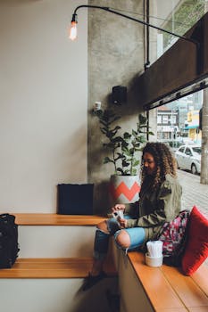 在一家拥有现代内饰和日光氛围的时尚咖啡馆里，一名年轻女子正在放松阅读