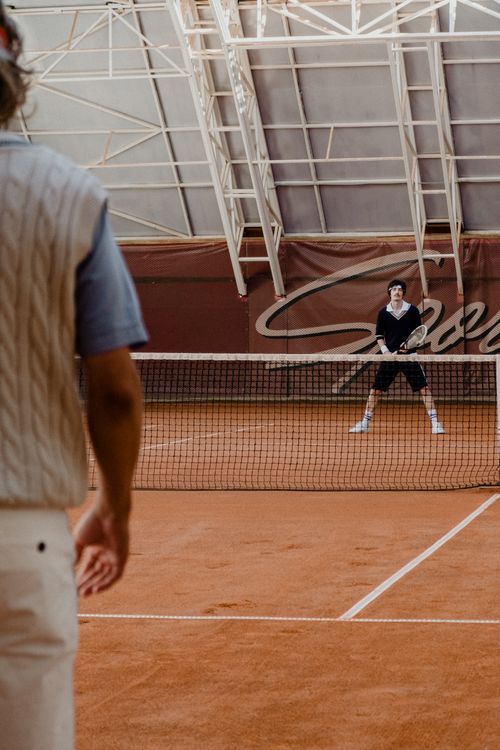 Free Two men playing tennis indoors on a clay court with stylish vintage attire. Stock Photo