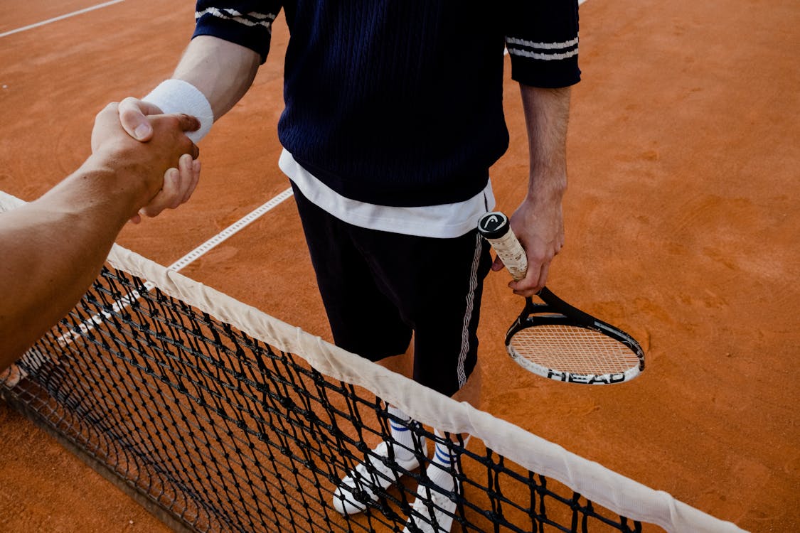 People Shaking Hands in a Tennis Match