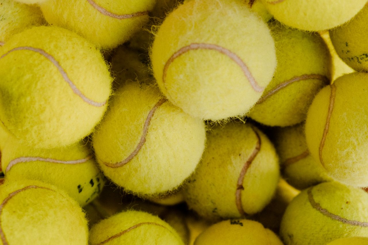 a macro shot of brightly colored yellow tennis balls grouped together