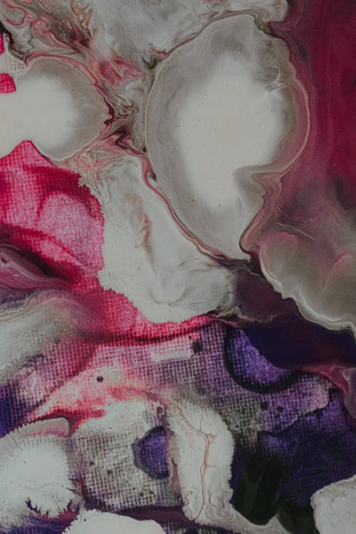 Overhead view of abstract backdrop of mixed watercolor paints with big blots and wavy lines