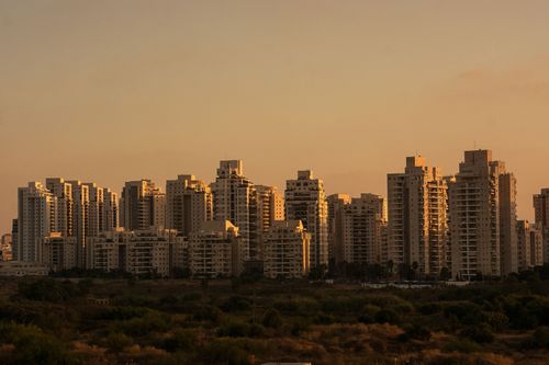 Free City skyline with tall skyscrapers silhouetted against a sunset sky. Stock Photo