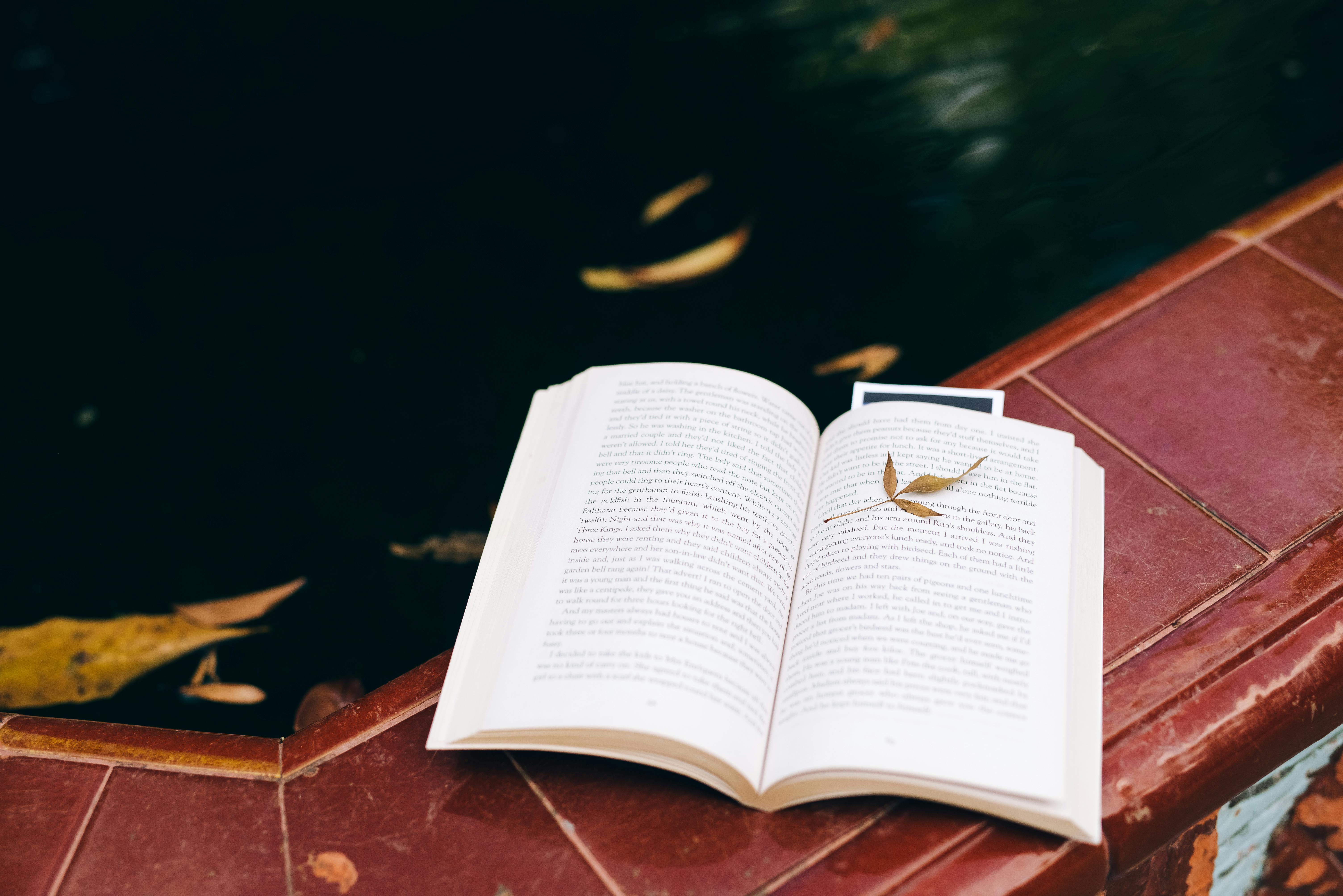 opened book on brown wooden table