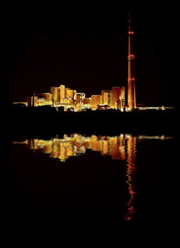 工业综合体的明亮灯光在夜间倒映水中，展现出建筑的辉煌