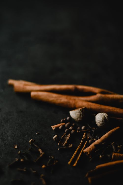 Free Cinnamon sticks and assorted spices artfully arranged on a dark surface. Stock Photo